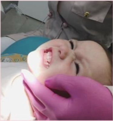 Bebê sorrindo durante consulta de odontopediatria